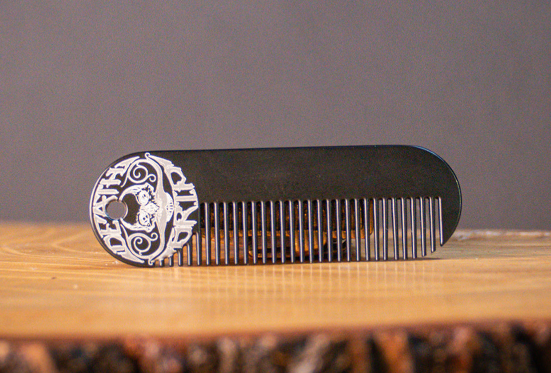 Death Grip Wax metal mustache and beard pocket comb on wooden surface