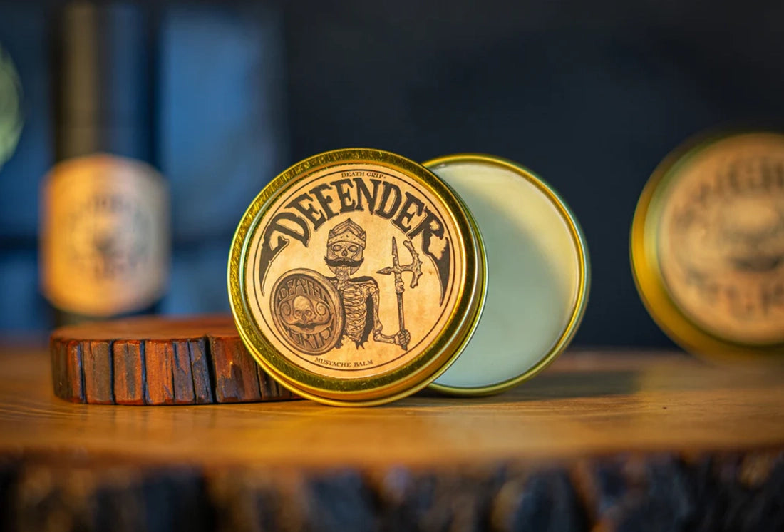 Death Grip Defender Mustache Balm 2oz open tin showing balm texture on wooden surface