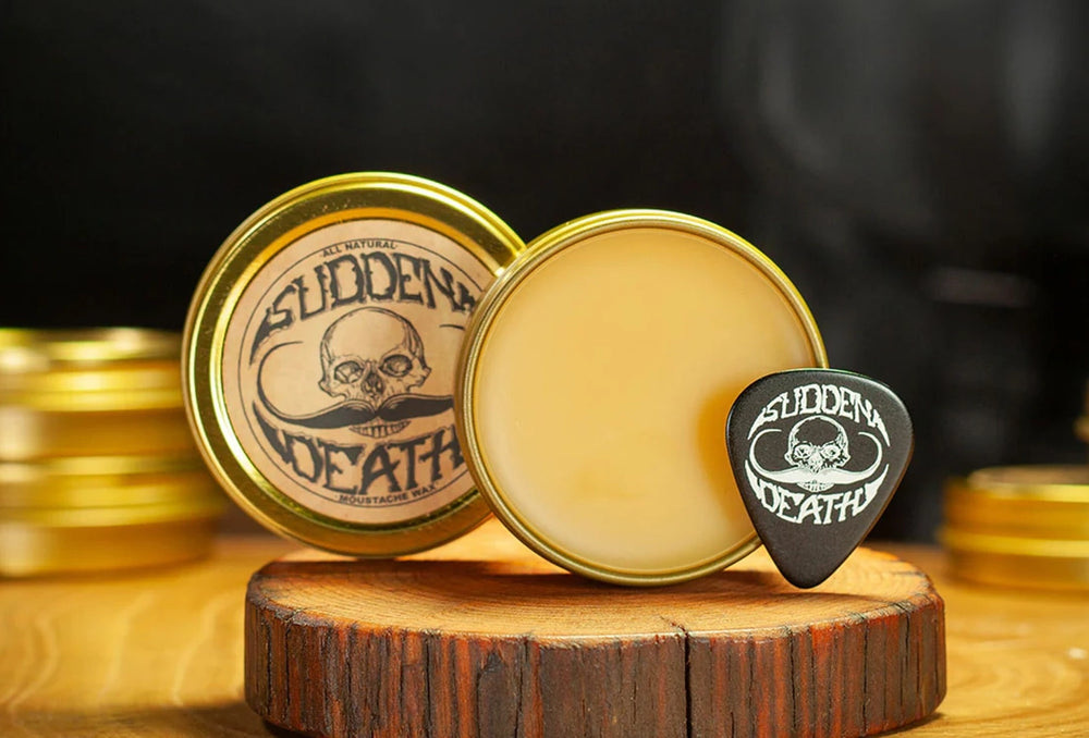 Sudden Death Grip mustache wax open tin with wax and branded pick on wooden stand with blurred tins in background