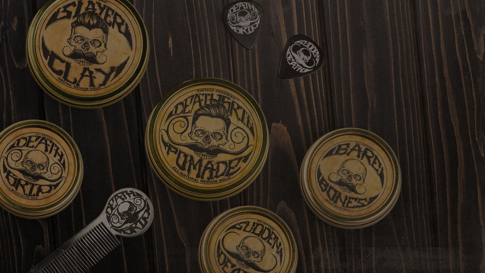 Death Grip mustache wax collection with multiple tins, comb, and picks on wooden surface